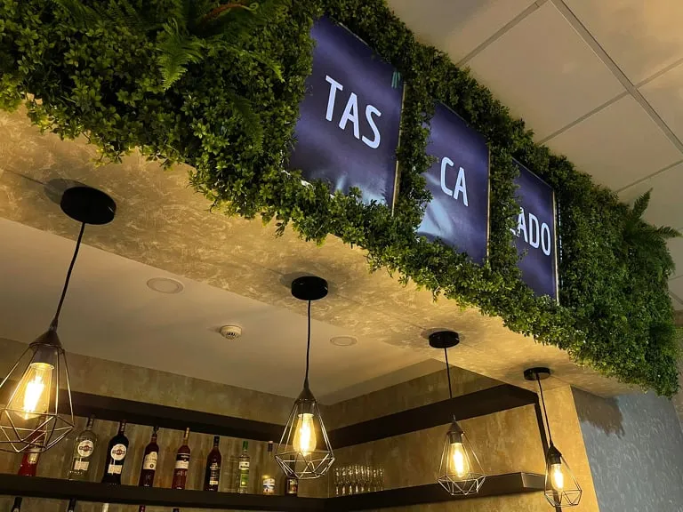 Interior da Tasca'lado, com o letreiro por cima do bar